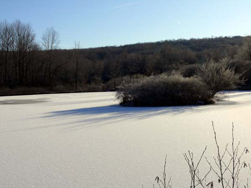 A frozen, snow covered pond