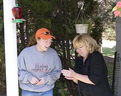 Two women holding a Rufous Hummingbird prior to release