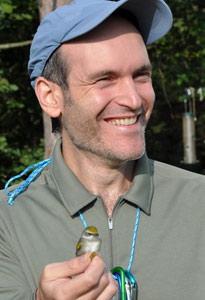 Man in blue hat holding a bird