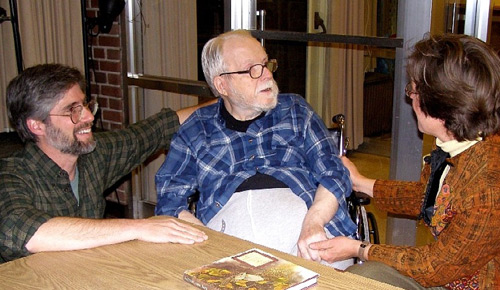 Middle-aged man, elderly man in wheelchair, and woman