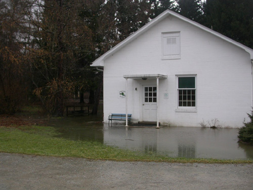 Exterior of white building, flooding around outside