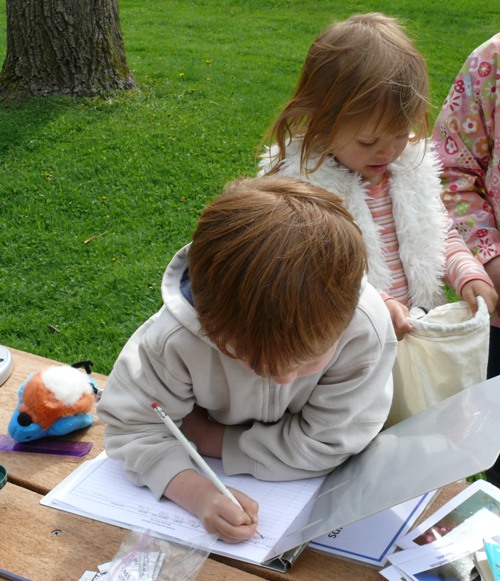 Two children taking notes at Pledge to Fledge day