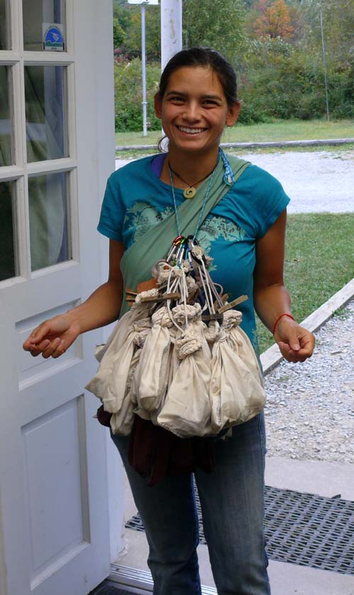 young woman with cloth bird bags attached to a harness across her chest