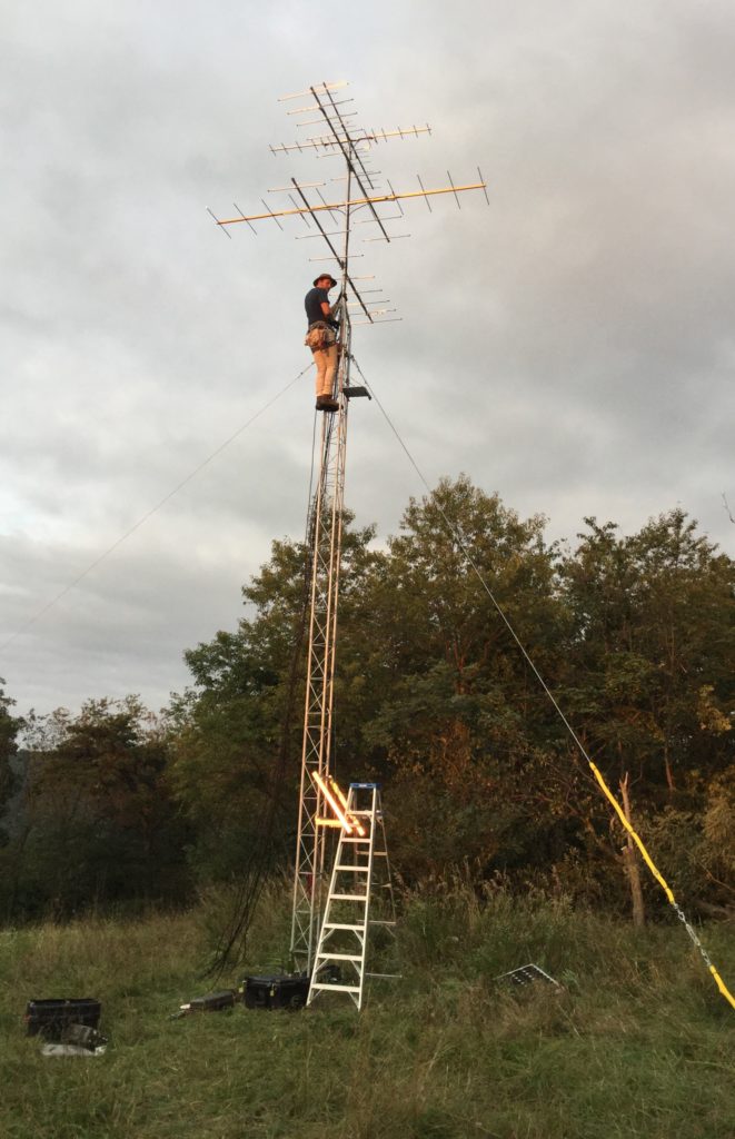 Field technician setting up Motus tower